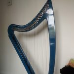 Stephs new harp standing next to the wall in her home